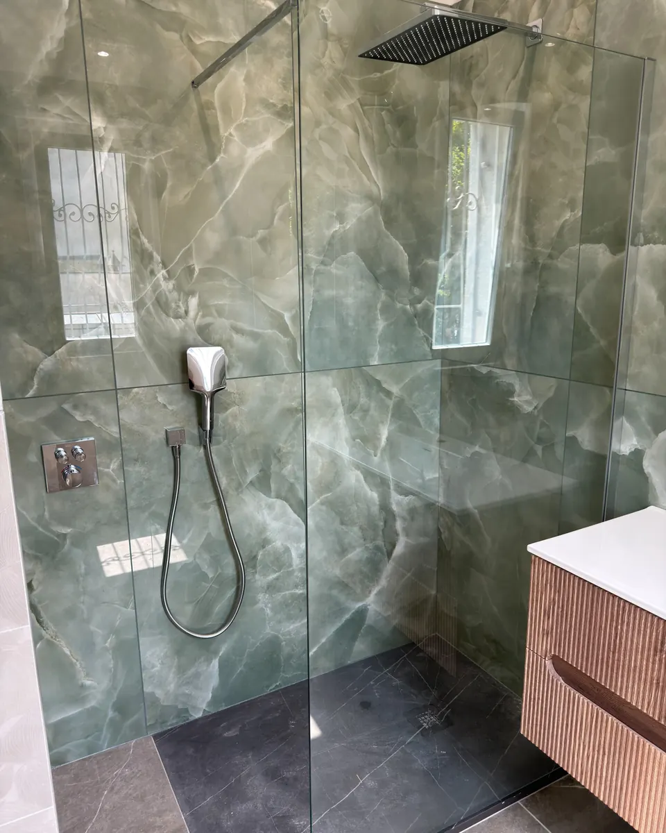Doccia walk-in con soffione a pioggia, rivestimento marmo verde
